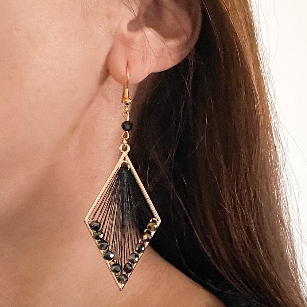 Statement oorbellen met zwarte facetkraaltjes en goudkleurige afwerking